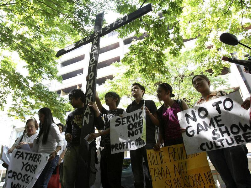 Journalism students and activists display a wooden cross and placards as they picket the office of the broadcasters' association in the Philippines, the KBP (Kapisanan ng mga Brodkaster ng Pilipinas) at the financial district of Makati city, south of Mani