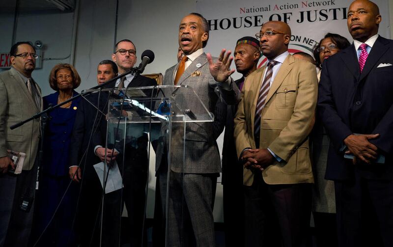 Rev. Al Sharpton, standing with Mark Lee, top center left, CEO of Barneys New York, addresses member of the media Tuesday, Oct. 29, 2013, at the National Action Headquarters in New York. Sharpton, president of the National Action Network, is a Baptist min