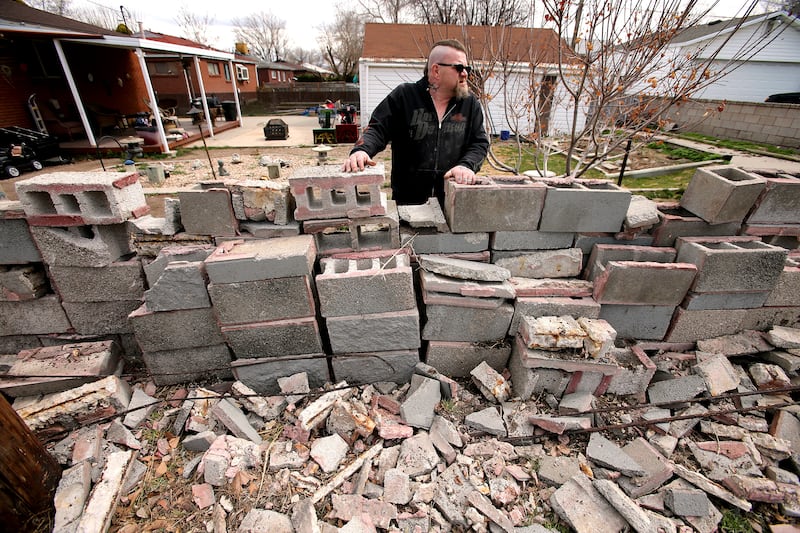 Chip Simpson looks up the street from behind what was a nearly 6-foot tall block wall that was destroyed during a 5.7 magnitude quake on Wednesday, March 18, 2020.