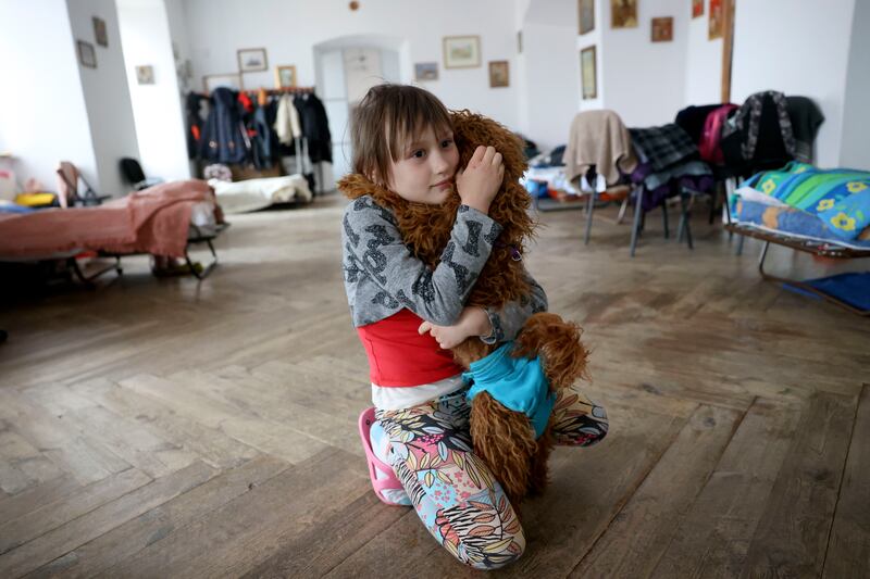 Young Ukrainian refugee Anastacia Luschyk holds her dog Sonic in Przemysl, Poland.