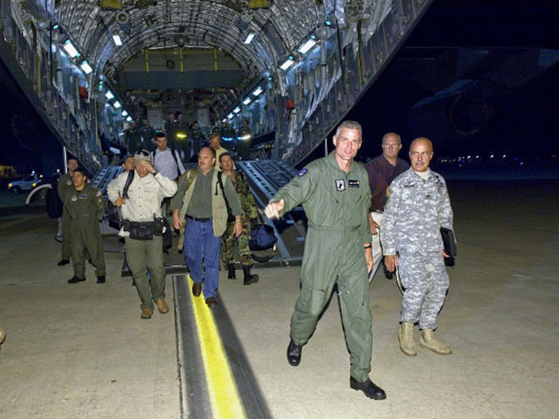 Former American hostage Keith Stansell, third from right, steps off the ramp of a C-17 Globemaster III onto U.S. soil at Lackland Air Force Base, Texas, late Wednesday. Three U. S. citizens employed by Northrup Grumman Corp., Marc Gonsalves, Thomas Howes