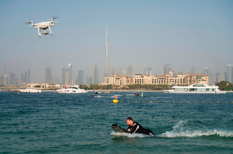 A drone follows a man riding a motorized surfboard in Dubai, United Arab Emirates.
