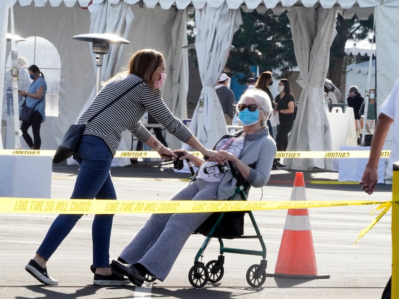 People walk after receiving their vaccines at the Disneyland Resort, serving as a Super POD (Point of Dispensing) COVID-19 mass vaccination site in Anaheim, Calif., Wednesday, Jan. 13, 2021.