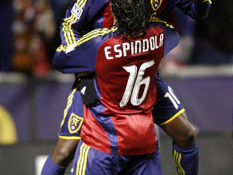 Fabian Espindola picks up Robbie Findley as they celebrate RSL's playoff-clinching win over Colorado Saturday.