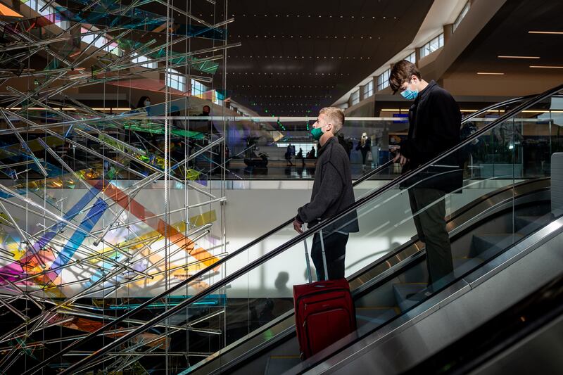 Travelers ride an escalator past “The Falls,” an art installation by Gordon Huether, at Salt Lake City International Airport.