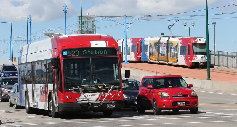 A UTA bus and TRAX train move through Salt Lake City on Tuesday, April 4, 2017.