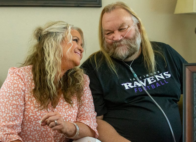 Stacey Ellsworth leans into her husband Stan Ellsworth at their home.