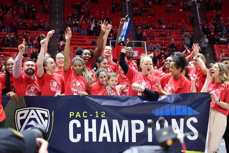The Utah team celebrates a win and becoming co-Pac-12 champions after an NCAA college basketball game against Stanford.