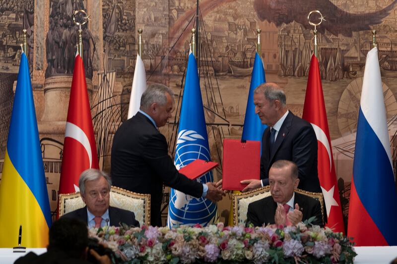 Turkish President Recep Tayyip Erdogan, right, and U.N. Secretary General, Antonio Guterres, sit as Sergei Shoigu, Russia’s Defense Minister, and Hulusi Akar, Turkey’s Defense Minister, shake hands during a signing ceremony at Dolmabahce Palace in Istanbul, Turkey, Friday, July 22, 2022.