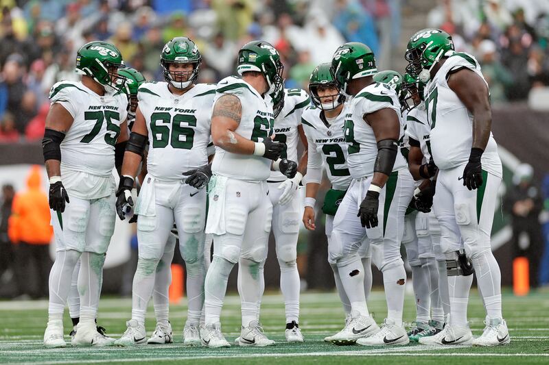 New York Jets quarterback Zach Wilson (2) huddles up with teammates against the New England Patriots Sunday.