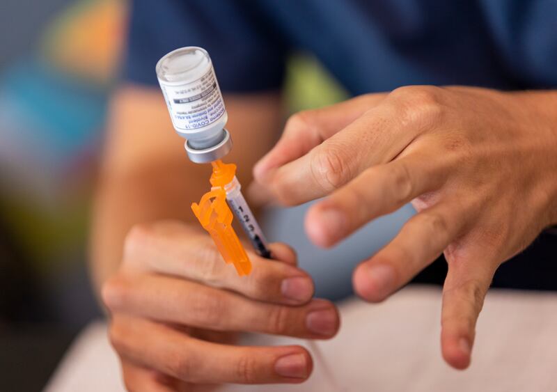 Nurse Aydan Elzinga prepares a COVID-19 booster shot at the Kearns Library in Kearns, Utah.