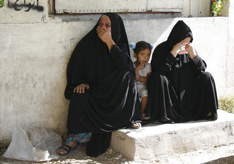 Iraqi women weep during a funeral after a U.S. airstrike in the Sihha district in southern Baghdad Friday. Iraqi police and witnesses said U.S. troops raided an apartment building in a Sunni neighborhood, killing at least 10 civilians and wounding 12. Als