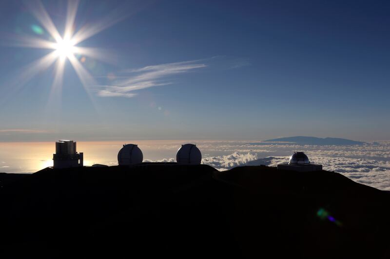 In this Sunday, July 14, 2019, file photo, the sun sets behind telescopes at the summit of Mauna Kea in Hawaii.