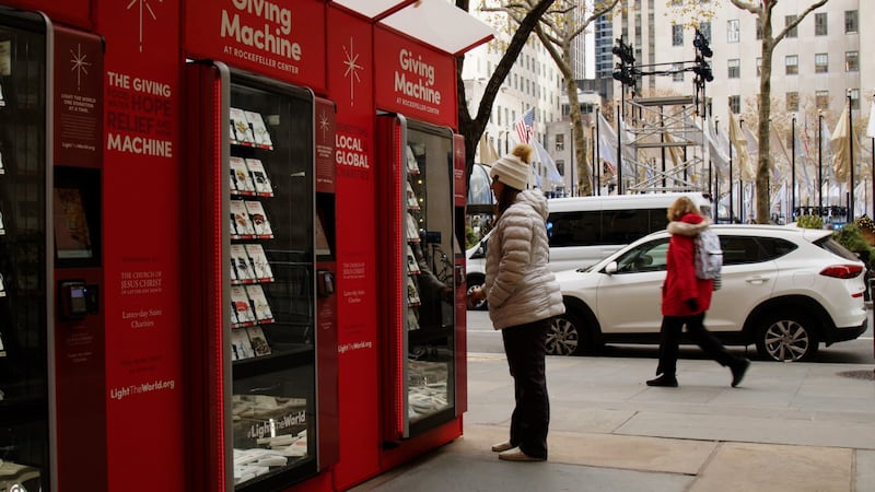 A New York City resident makes a donation at the Giving Machine at New York City’s Rockefeller Center.