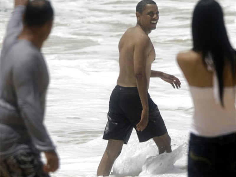 People on the beach call out to then-Democratic presidential candidate Barack Obama as he makes his way back into the water while body surfing during a trip to Honolulu, Hawaii, on Aug. 14.