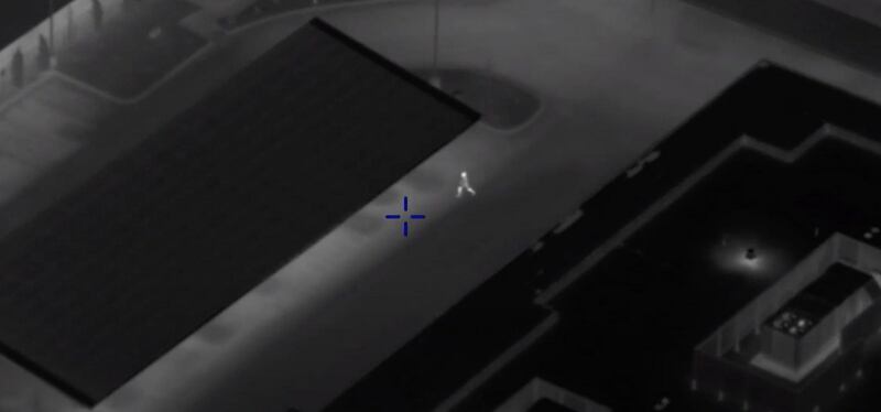 A man in the center is seen running across a parking lot after ditching a car while being chased by police on Feb. 17, 2022. A camera from a Utah Department of Public Safety helicopter is keeping track of his actions and relaying helpful information to officers on the ground.