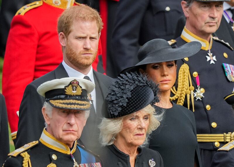 Britain’s King Charles III, Camilla, the Queen Consort, Meghan, Duchess of Sussex and Prince Harry watch as the coffin of Queen Elizabeth II is placed into the hearse.