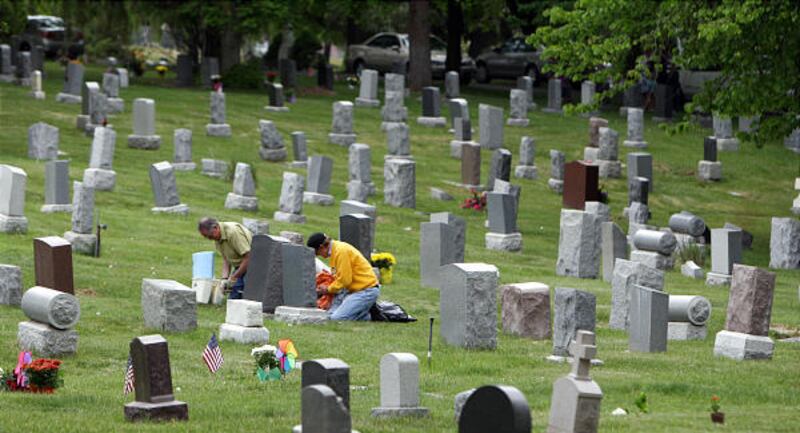 John Erlacher, left, and Lex Hemphill place flowers on the grave of their aunt and uncle at a cemetery in Salt Lake City in 2008.