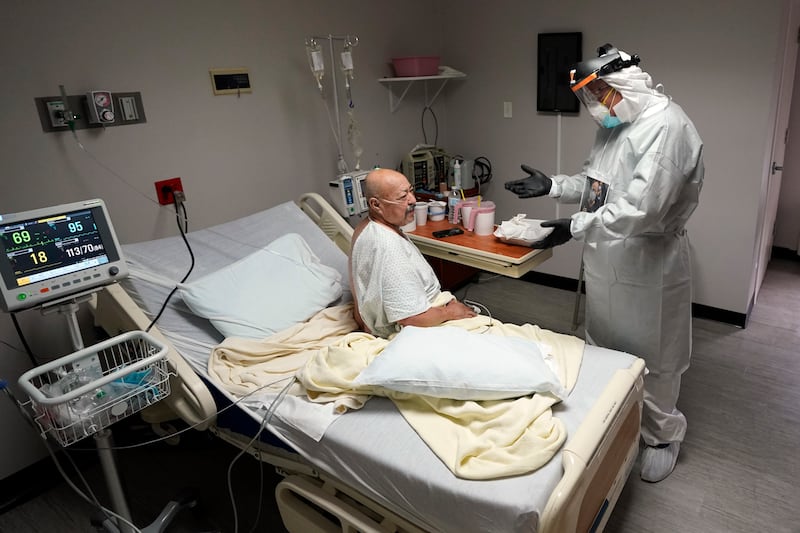 Dr. Joseph Varon, right, talks with patient Jose Tellez inside the Coronavirus Unit at United Memorial Medical Center, Monday, July 6, 2020, in Houston. Cases of COVID-19 are rising in Southern cities like Houston and leaving hospitals at a crisis point.