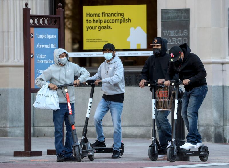 E-scooter riders wear masks in downtown Salt Lake City.