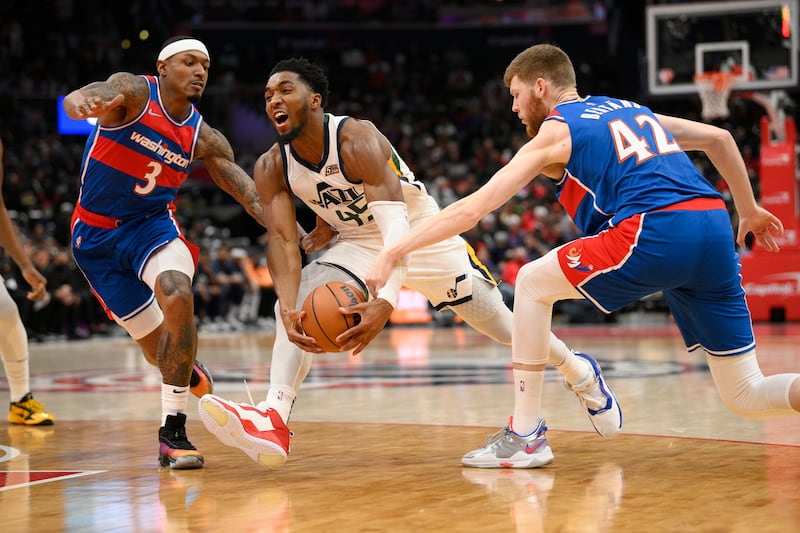 Utah Jazz guard Donovan Mitchell (45) drives to the basket against Washington Wizards guard Bradley Beal (3) and forward Davis Bertans (42).