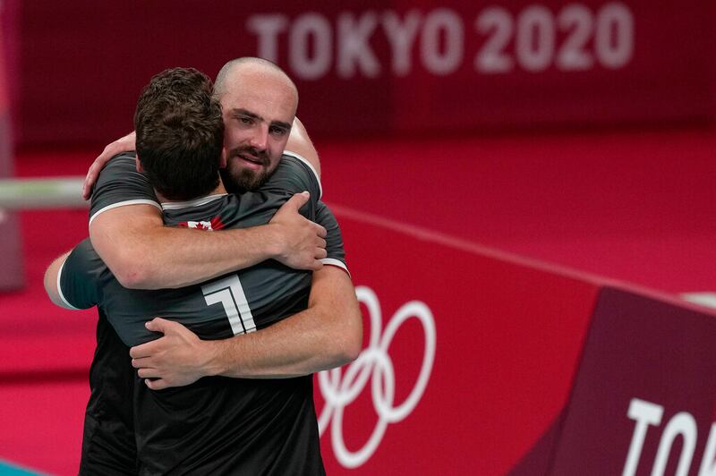 Canada’s Nicholas Hoag and Canada’s Tyler Sanders hug after losing the men’s volleyball quarterfinal match.