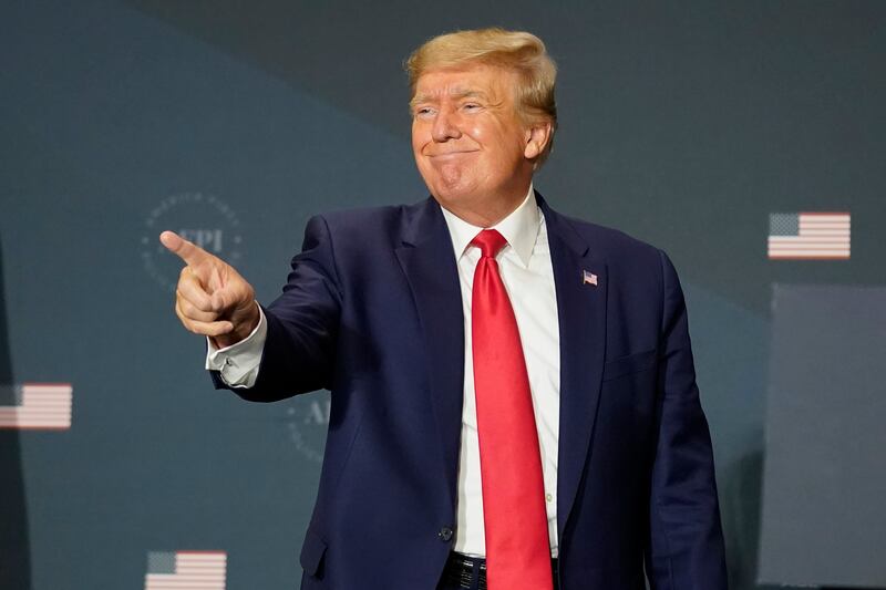 Former President Donald Trump gestures to the audience at an America First Policy Institute summit.