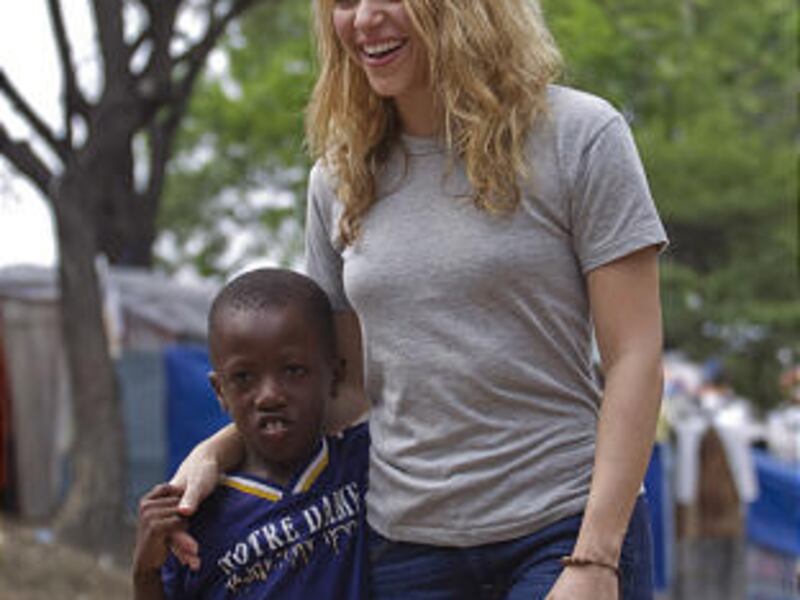 Pop singer Shakira laughs while embracing a child at a camp in Port-au-Prince Sunday.