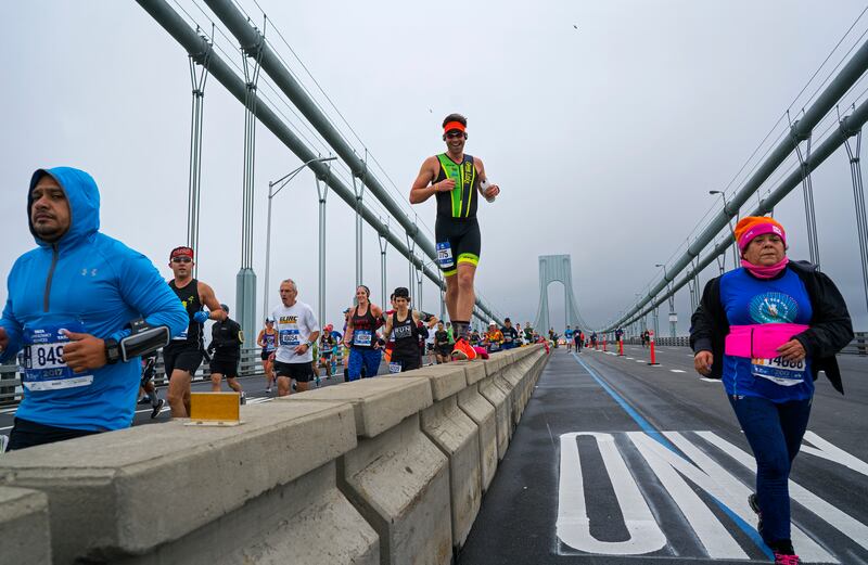 A runner uses the median barrier to make it part of the way across the Verrazano-Narrows Bridge during the New York City Marathon in 2017.