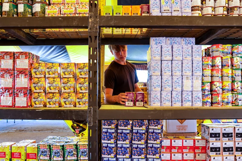 Riley Warner stacks fireworks in preparation for the Fourth of July weekend at a Pyro City fireworks tent in West Valley City on Monday, June 27, 2022.