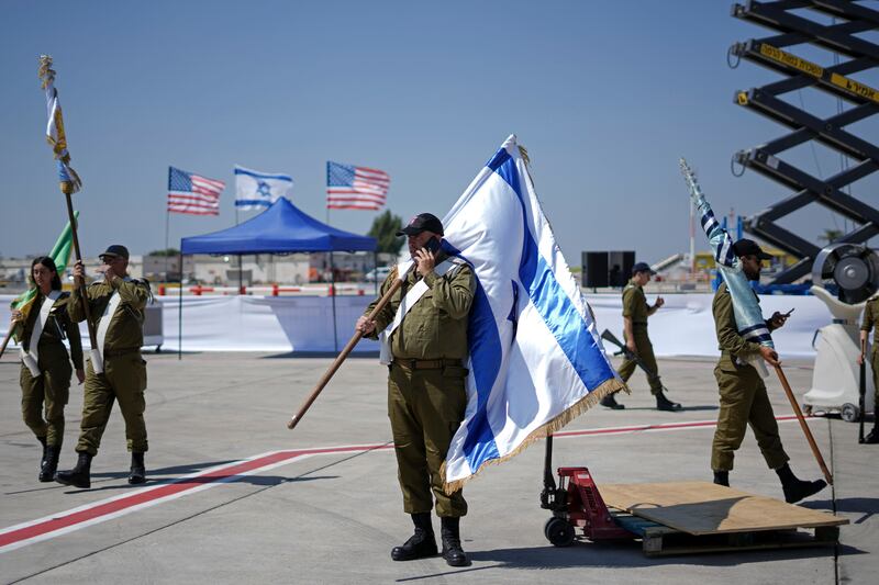Israeli soldiers use their mobile phones between rehearsals for the welcoming ceremony for U.S. President Joe Biden.