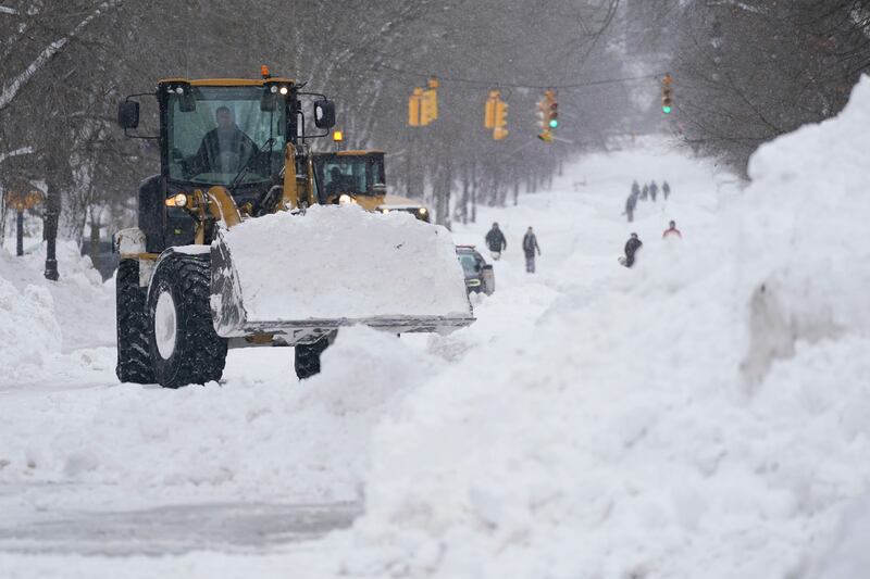 Workers use heavy equipment to clear snow from Richmond Avenue in Buffalo, N.Y.