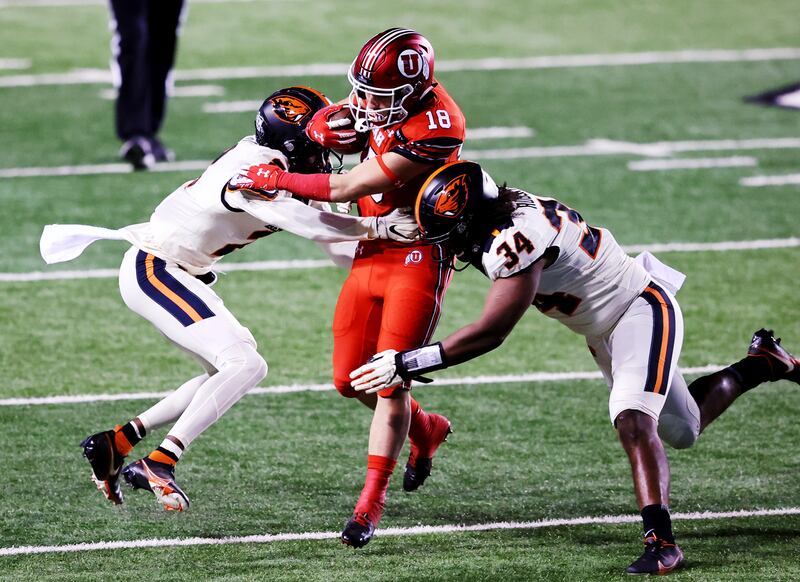 Utah Utes wide receiver Britain Covey (18) tries to split Oregon State Beavers defenders in 2020.