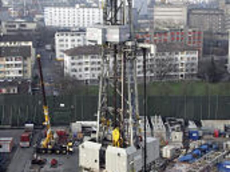 A drilling derrick rises 190 feet above nearby apartment buildings in Basel, Switzerland. Scientists estimate geothermal energy could provide 250,000 times more energy than the world currently uses.