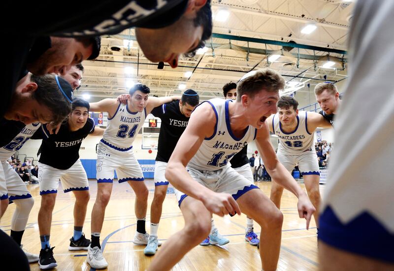 Yeshiva University Maccabees huddle around guard Ryan Turell (11) before a game, in New York, Feb. 25, 2020.