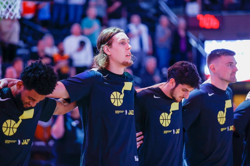 The Jazz lock arms during national anthem before playing the Mavericks in a preseason game in Salt Lake City, Oct. 14, 2022.