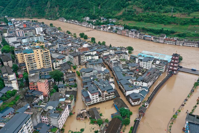 In this aerial photo released by China’s Xinhua News Agency, flooding is seen in Bikou township of Longnan city in northwestern China’s Gansu Province, Tuesday, Aug. 18, 2020. Authorities deployed helicopters in western China to rescue people stranded by flooding as heavy rain swelled rivers to dangerous levels, state media reported. (Du Zheyu/Xinhua via AP)