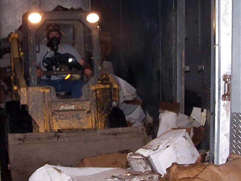 In this photo taken June 23, 2009, a worker uses a skid loader to remove some of the 44 tons of spoiled kosher bison meat from a locker at Bridgewater Quality Meats in Bridgewater, S.D.