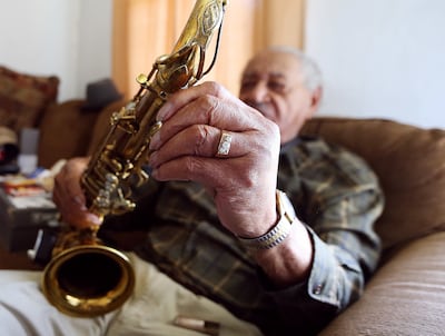 Saxophone player Joe McQueen, still going strong as he nears his 99th birthday, Joe adjusts his horn at his Ogden home on Saturday, May 26, 2018.