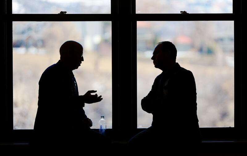 Two men sit on a window sill and talk on the fourth floor of the Capitol in Salt Lake City on Friday, Feb. 10, 2023.