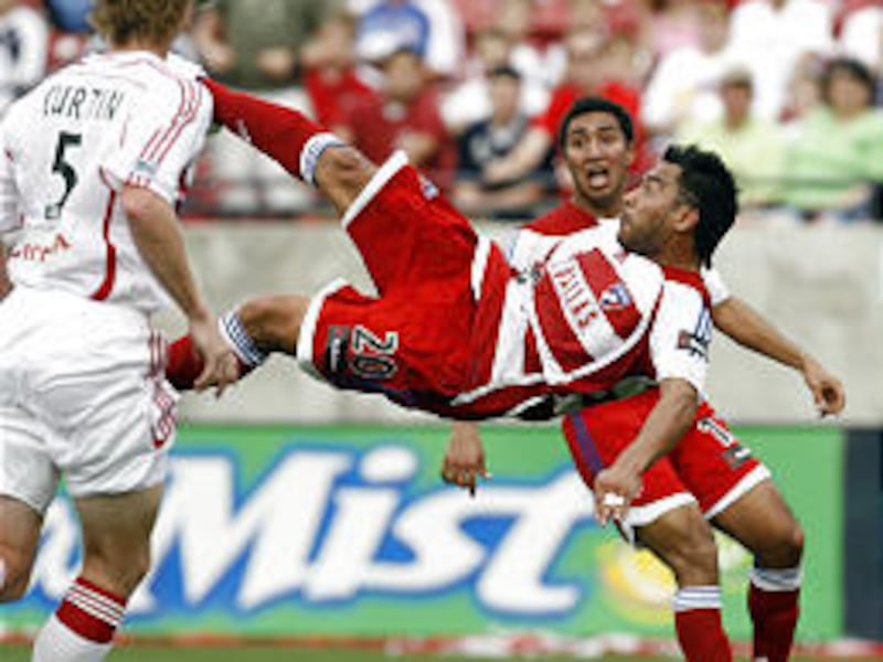 FC Dallas' Carlos Ruiz (20) flies into the air for a bicycle kick that just missed the goal.