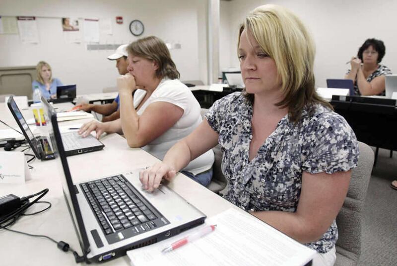 In this 2010 file photo, students attend an economics class at the University of Phoenix in Taylorsville, Utah, Thursday, Aug. 5, 2010. The University of Phoenix will be closing 115 locations around the country, including two in Utah.