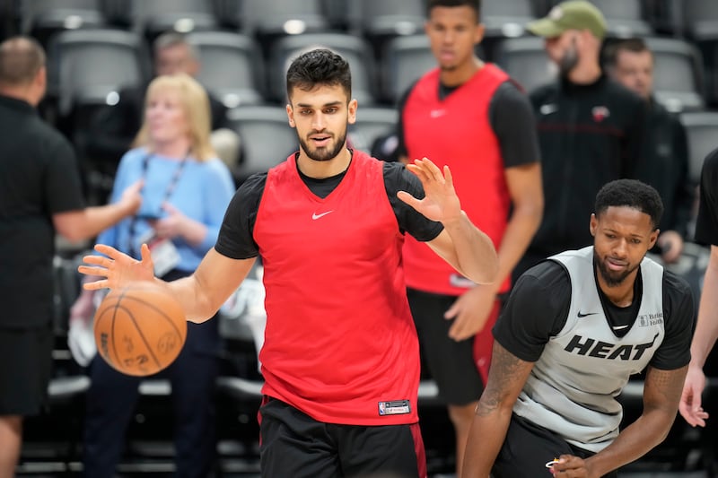 Miami Heat center Omer Yurtseven, left, looks to control the ball as Miami Heat forward Haywood Highsmith defends.
