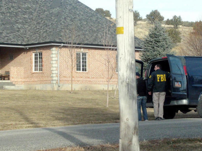 Securities and Exchange investigators confer with the driver of the one of the FBI vans during the raid on the headquarters of Management Solutions in Fountain Green on Friday, Dec. 16, 2011. About seven or eight agents removed records from the building a