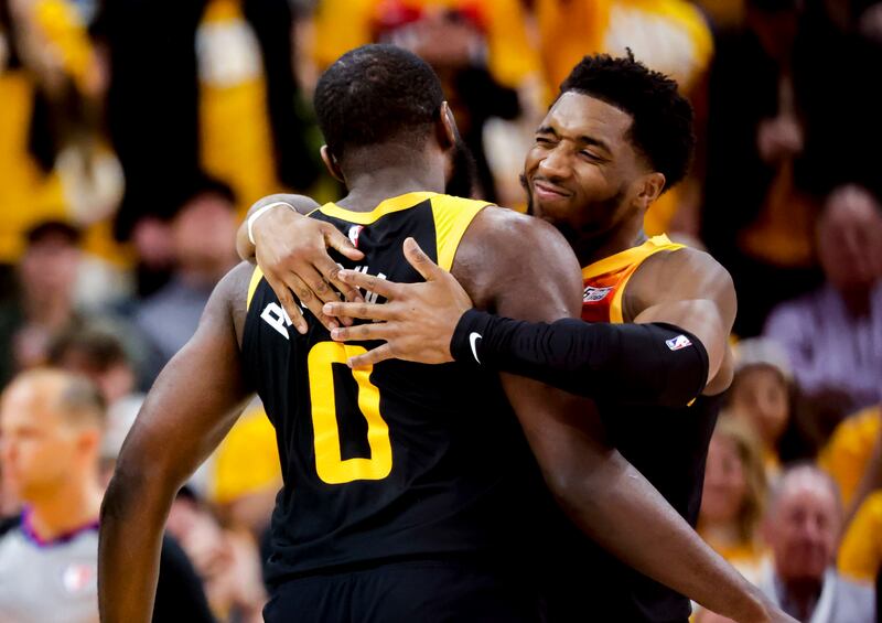 Utah Jazz guard Donovan Mitchell hugs Utah Jazz forward Eric Paschall (0) after a play as the Jazz and Mavericks in playoffs.