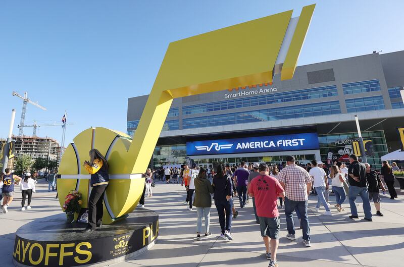 Fans pass by the Jazz logo statue as they enter Vivint Arena in Salt Lake City.