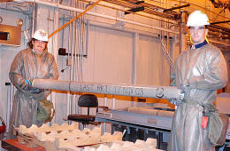 Jack Anderson, left, and Bryan Clark place the last VX rocket onto the processing line at the depot.