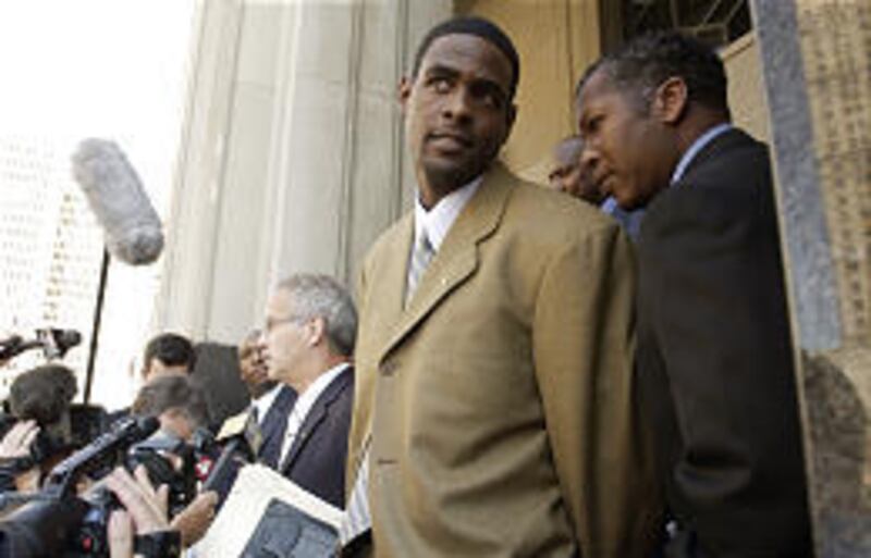 Sacramento Kings' Chris Webber waits while his lawyer talks to reporters outside federal court Tuesday.