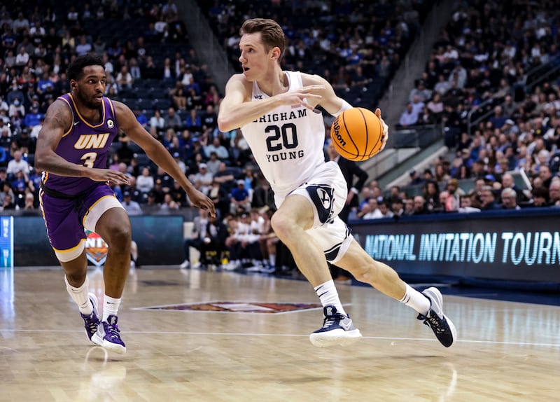 Brigham Young Cougars guard Spencer Johnson wearing white, drives on Northern Iowa Panthers guard Tywhon Pickford