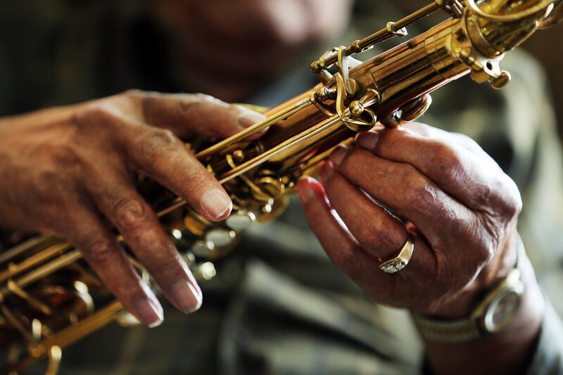 Saxophone player Joe McQueen, still going strong as he nears his 99th birthday. McQueen adjusts his horn at his Ogden home on Saturday, May 26, 2018.